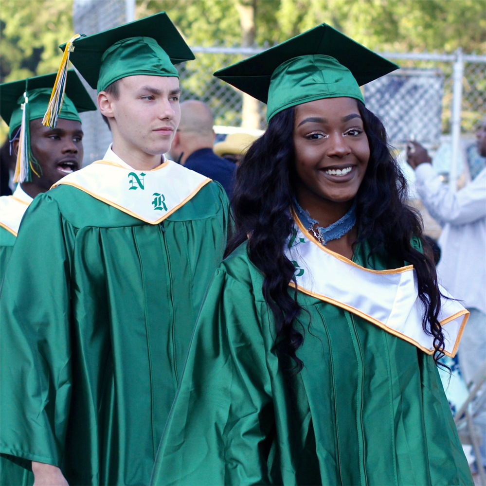 graduates in green graduation gowns